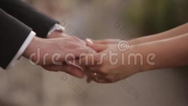 婚礼当天，新郎把结婚戒指戴在新娘的手指上。 新娘把戒指戴在新郎的手指上